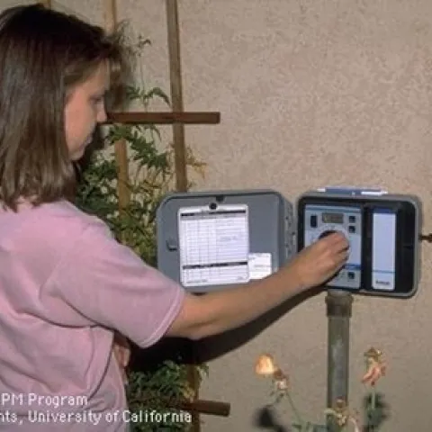 Photo of woman adjusting her irrigation controller
