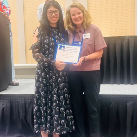 Yu Meng, receives the NEAFCS New Professional Award from Western Region President Dianne Christensen.