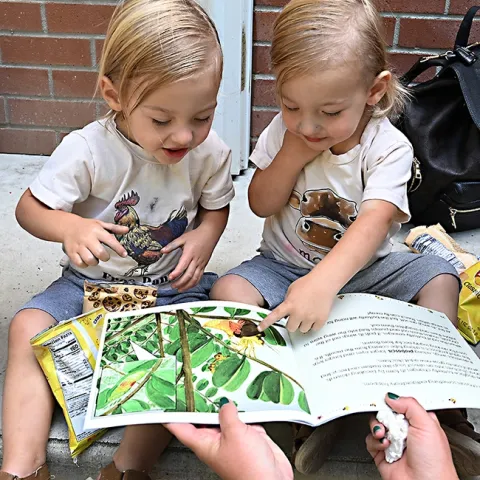 A children's book on the California state insect, the dogface butterfly, draws the interest of twins Ford and Wyatt Devine, 2, of Vacaville.The book was displayed at the Vacaville Museum Guild's Children's Party. (Photo by Kathy Keatley Garvey)