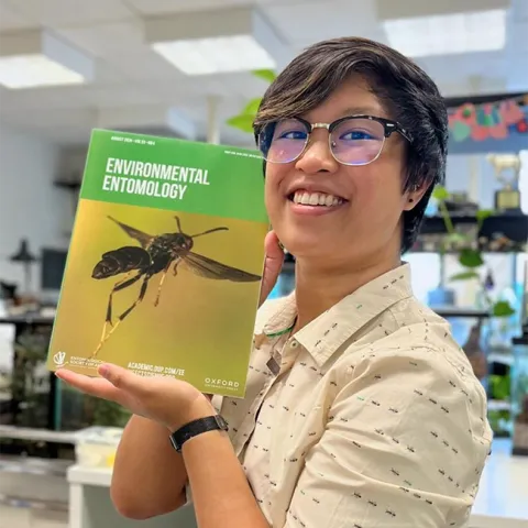 RJ Millena, a doctoral candidate of comparative biology in the lab of Professor Jessica Ware, American Museum of Natural History (AMNH) holds a copy of the journal "Environmental Entomology." Her research is the cover story. (Photo by UC Davis alumnus Lohit Garikipati, now a doctoral student at AMNH)