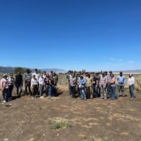 A group photo in open space under a blue sky.