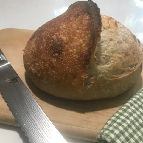 sourdough boule with bread knife and towel