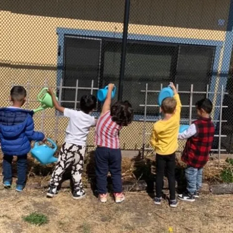 Fairmont Elementary students work in the garden under the watchful eye of their teacher.