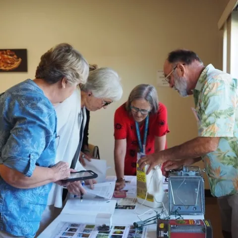 Group of people looking at items on a table
