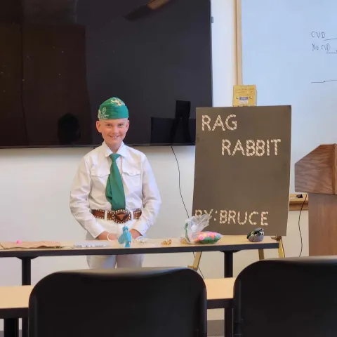 Youth standing in front of room with a display board