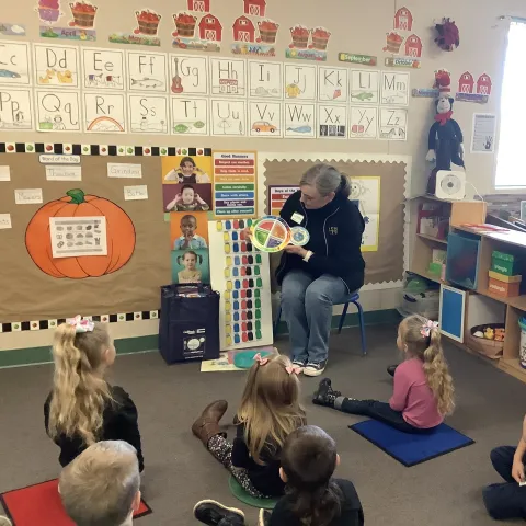 An educator demonstrations food portions for preschoolers using MyPlate