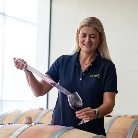Anita sampling wine from barrel