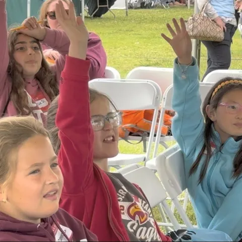 Students enthusiastically engage with a water filtration demonstration during the Children's Water Education Festival