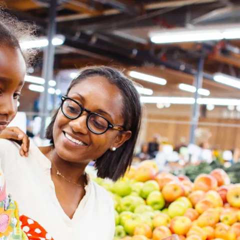 Mother and child in grocery store produce section