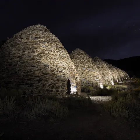 Charcoal kilns lit up at night.