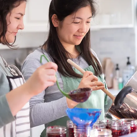 Two women water bath canning jam