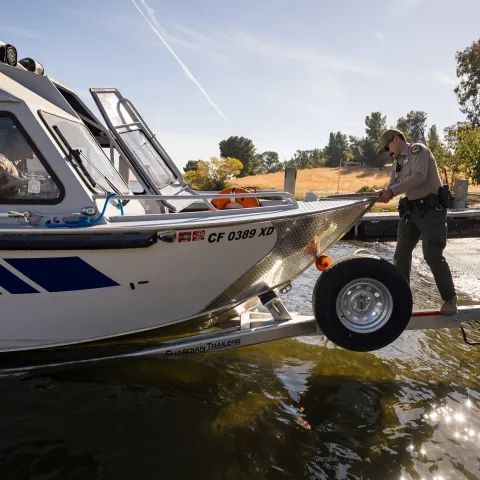 A staff person from the California Department of Fish and Wildlife inspects a boat.