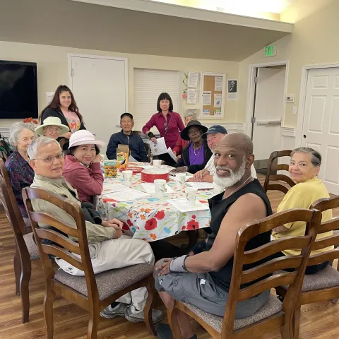 Twelve people of mixed races sitting around a dining table