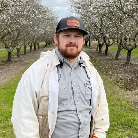 Joseph Tauzer in an almond orchard in Hamilton City. (Photo by Kian Nikzad)