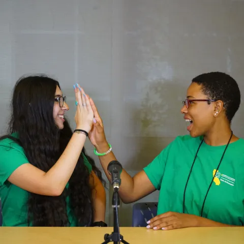 Two 4-H teens giving each other a high five. 