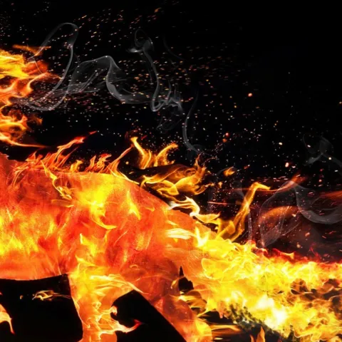 a horse made of fire running across a black background