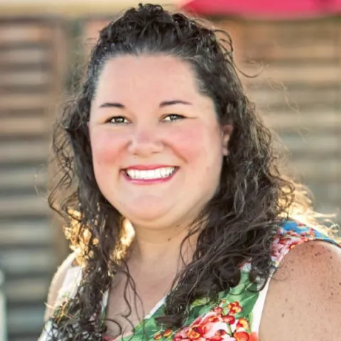Nicholle Peterson with natural light with wood slats as background