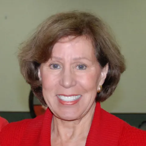 A smiling Master Gardener in a red top.
