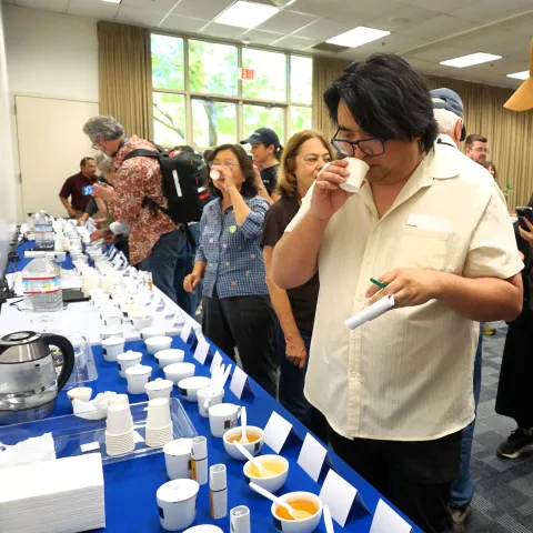 Two Kearney REC Tea Day attendees put their noses into cups to evaluate the aroma of various teas