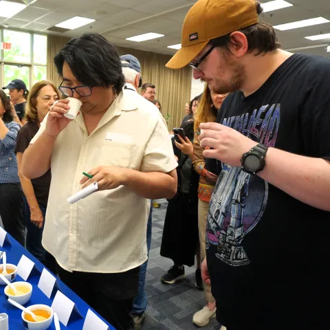 Two Kearney REC Tea Day attendees put their noses into cups to evaluate the aroma of various teas
