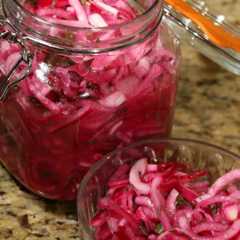 two glass jars of pickled red onions