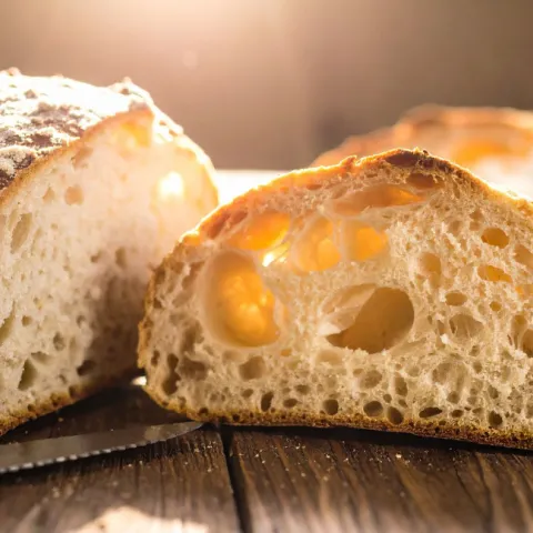 Sourdough loaf cut on half on the table.
