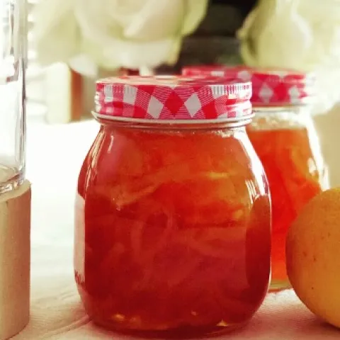 jars of strawberry lemon marmalade with whole lemons in the foreground