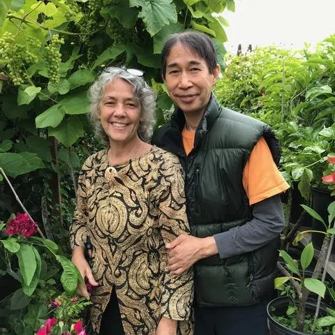 a man and a woman stand in a garden