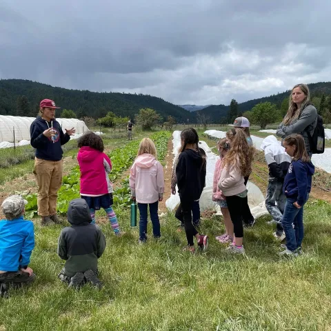 Lost Sierra delivering work in a farm field with youth.