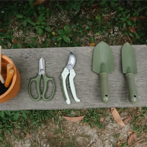Gardening tools on wooden bench in yard By: Gary Barns from Pixels
