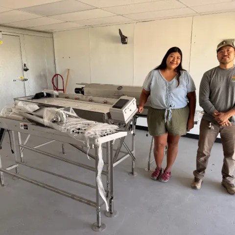 Two clients standing in a room near a walk in cooler.