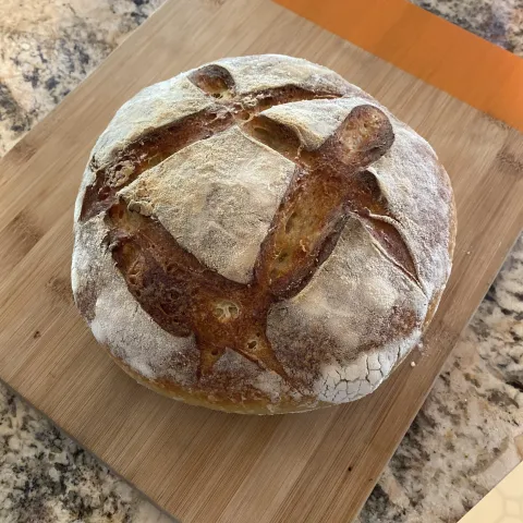 round loaf of sourdough bread on a wooden cutting board