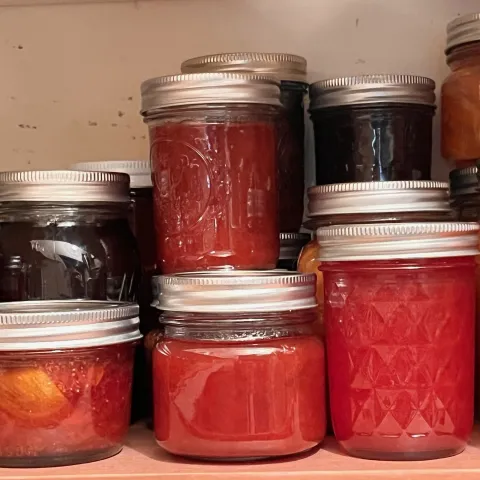 Jars of jams, jellies, and chutneys in a well-stocked pantry. J.C. Lawrence