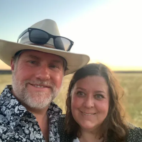 Two people standing next to each other in a grain field