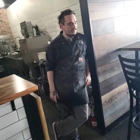 Person standing against a door frame in a restaurant