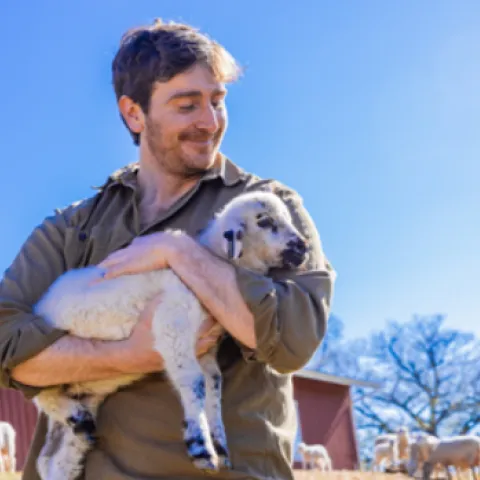 man holding a lamb in his arms