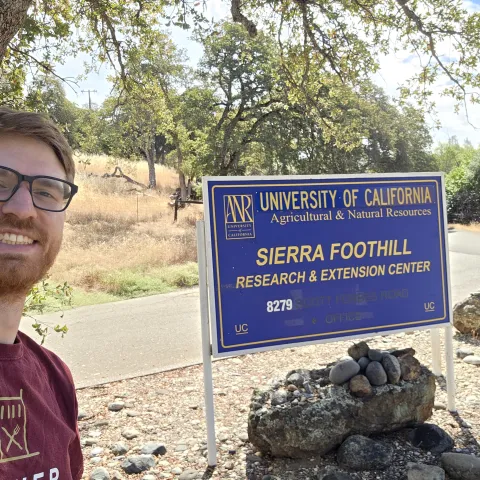Conor McCabe next to Sierra Foothill Research and Extension Center sign