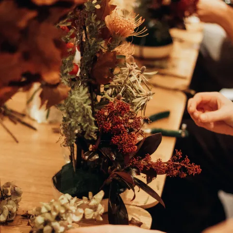 floral arranging class, hands and floral items on wooden table
