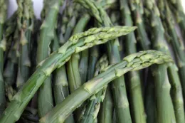 Close-up of fresh green asparagus stalks, showcasing their vibrant color and varied textures.