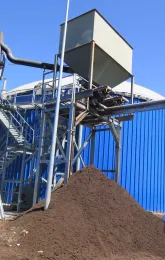 A mound of compost outside of a plant.