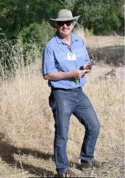 Bell stands in in dry grass.