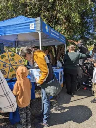 Two people spin the Pollinator Wheel.