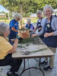 Smiling women work at a table full of lavender.
