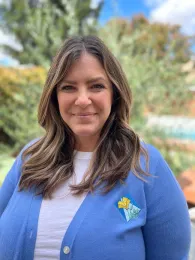 Melissa is wearing a blue sweater with the UC Master Gardener logo on it.