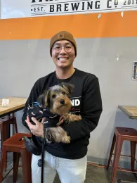 Jordan is holding a brown and black dog