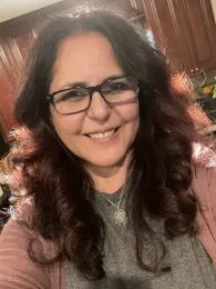 Woman with long dark brown hair and glasses