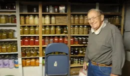 Author's grandfather standing in front of shelves full with preserved food