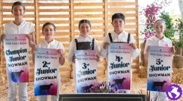 Five 4-H youth hold up posters showing 1st through 5th place at a dairy competition.