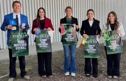 Five 4-H youth hold up posters showing 1st through 5th place in the senior division at a dairy competition.
