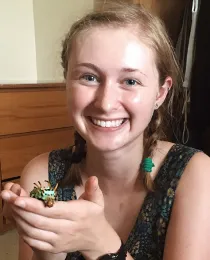 UC Davis doctoral candidate Grace Horne holding a hickory horned devil caterpillar (Citheronia regalis).